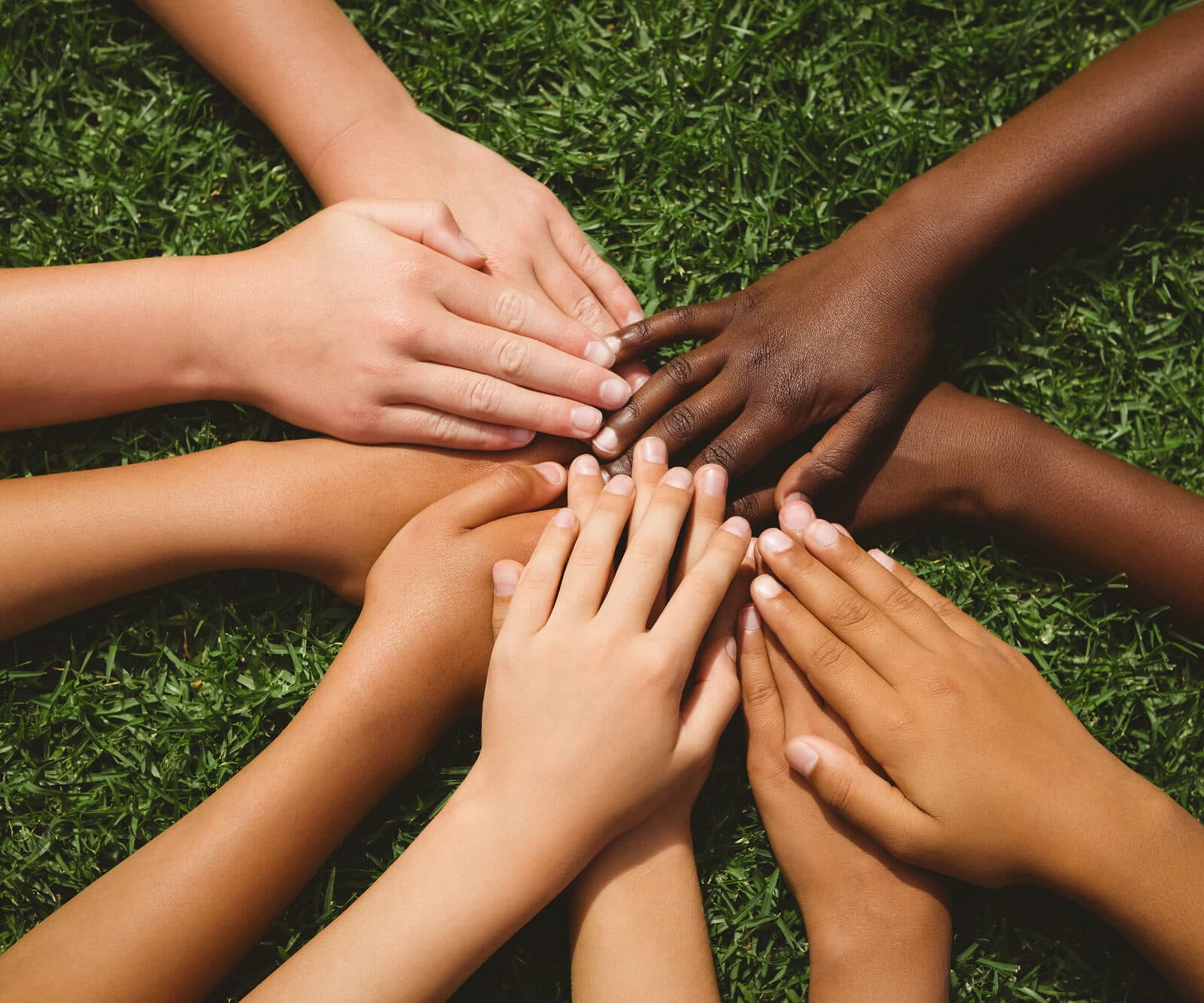 Barn som håller händerna tillsammans på gräs
