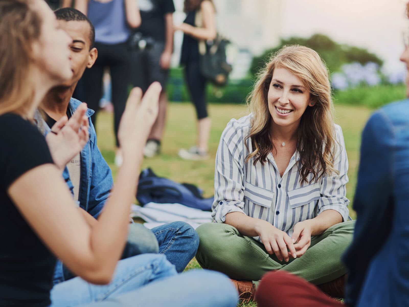 Människor som sitter på en gräsmatta och pratar